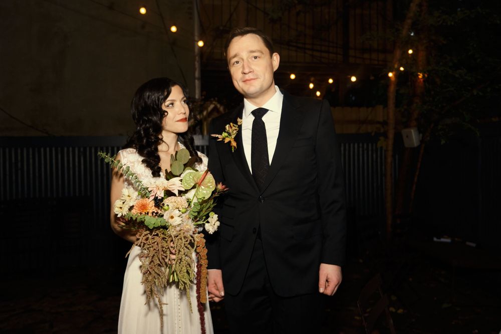A couple shares a romantic moment during their outdoor evening wedding reception at Mayson May