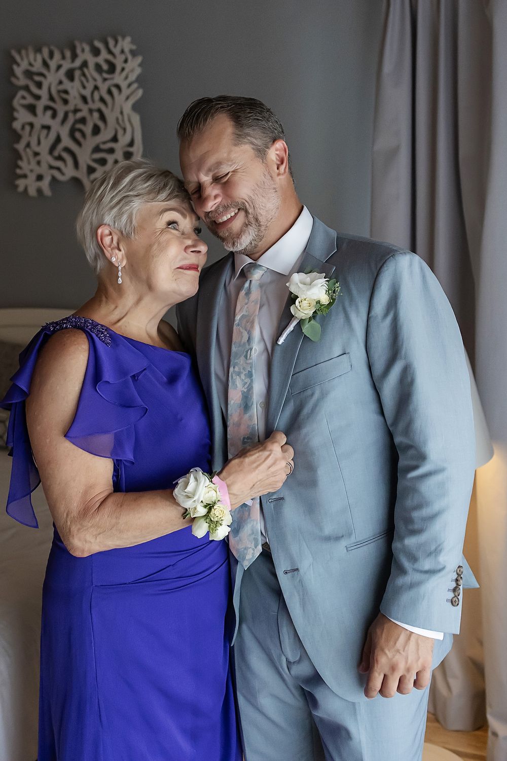 Groom with mother before ceremony, emotional moment in Mexico.