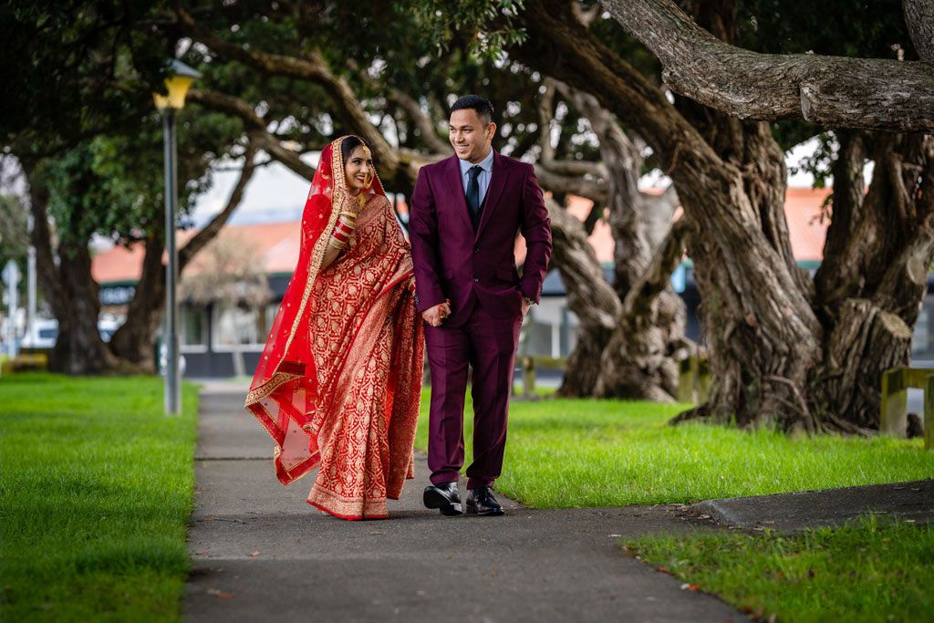 couple holding their hands and walking during wedding reception at moera community hall, lowerhutt
