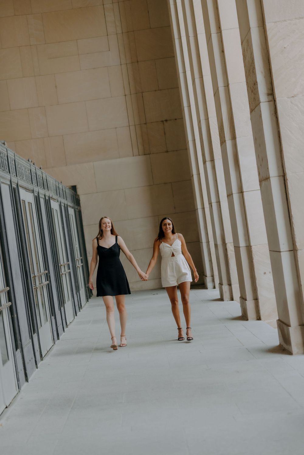 Same-sex couple walking hand in hand outside Civic Auditorium, Grand Rapids wedding photographer.