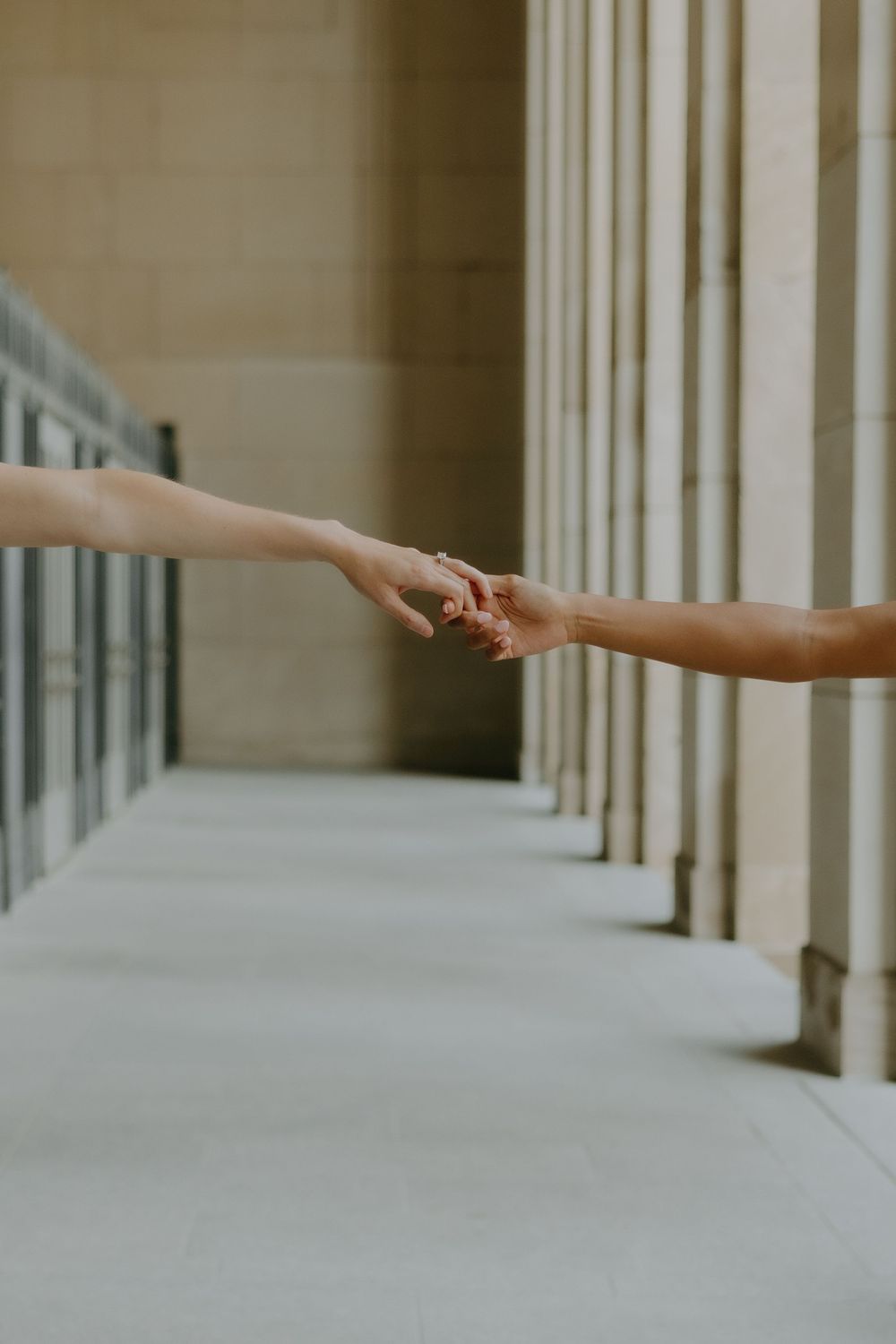 Close-up of LGBTQ+ couple holding hands — soft romantic tones by inclusive wedding photographer.