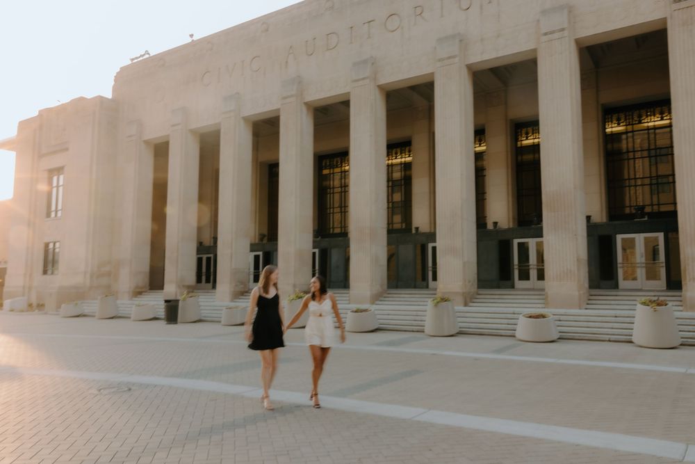 Same-sex couple walking hand in hand outside Civic Auditorium, Grand Rapids wedding photographer.
