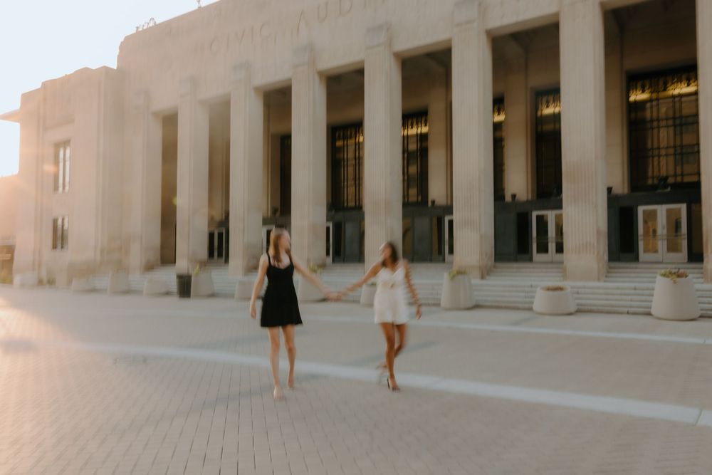 Engaged LGBTQ+ couple smiling during downtown photo session by Grand Rapids wedding photographer.