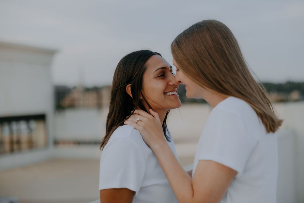 Intimate forehead-to-forehead moment between two brides captured by inclusive wedding photographer.