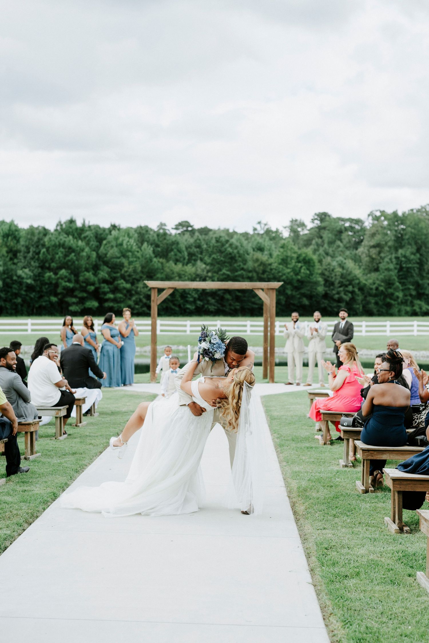 Emotional moment during wedding ceremony with guests seated on wooden benches.