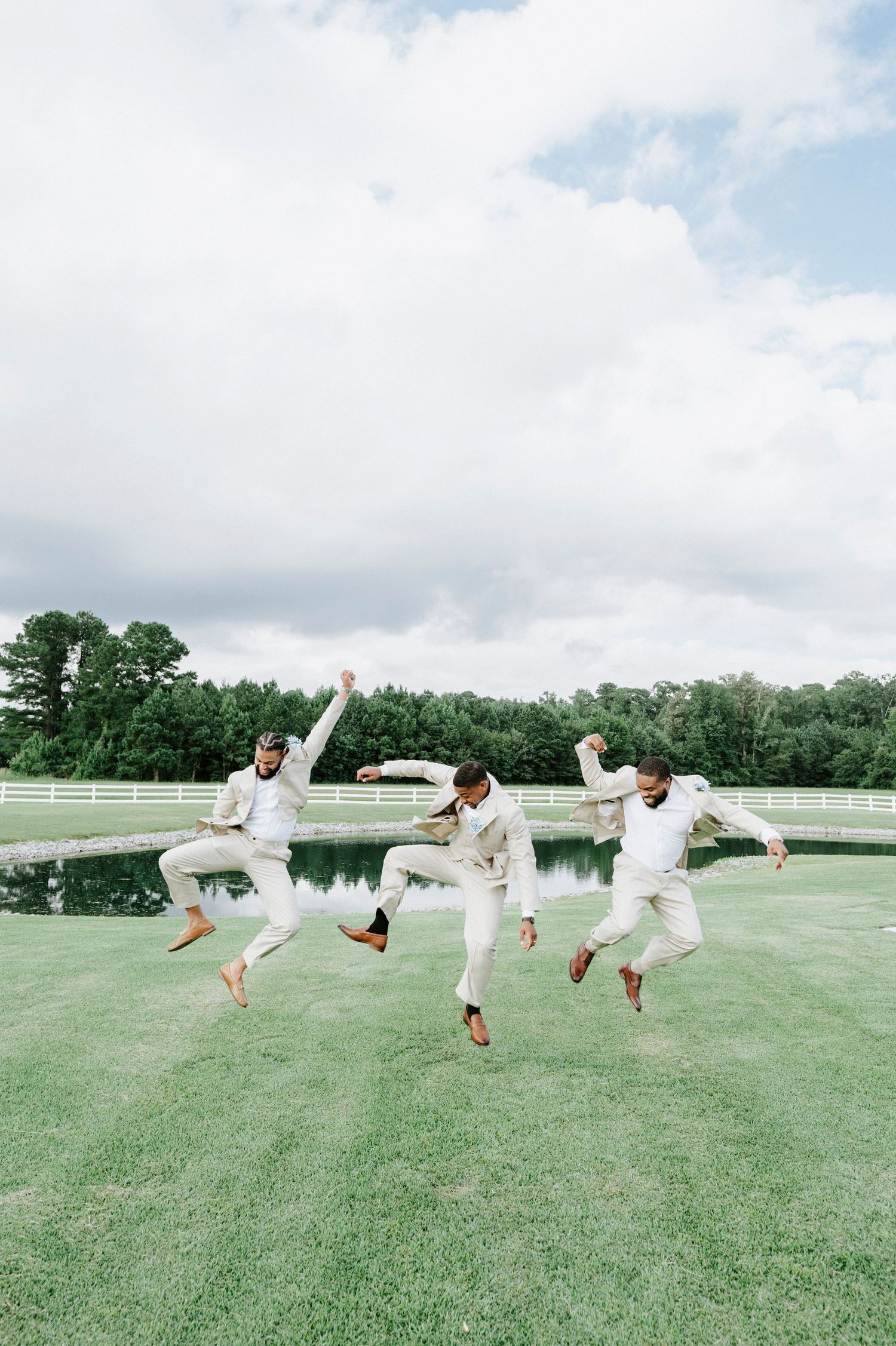 People in white outfits performing synchronized jumps on a lush green lawn.