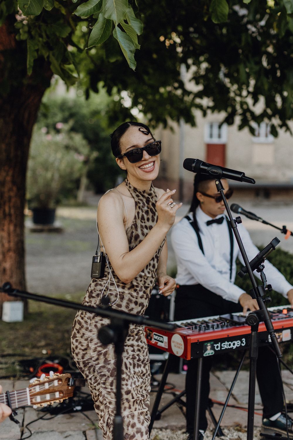 Sängerin bei einer Hochzeit am Abend, sie trägt eine Sonnenbrille und tanzt zur Musik.
