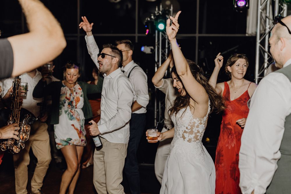 Hochzeitsparty im Hofgut Heidesheim, alle tanzen und hüpfen, die Stimmung ist ausgelassen.