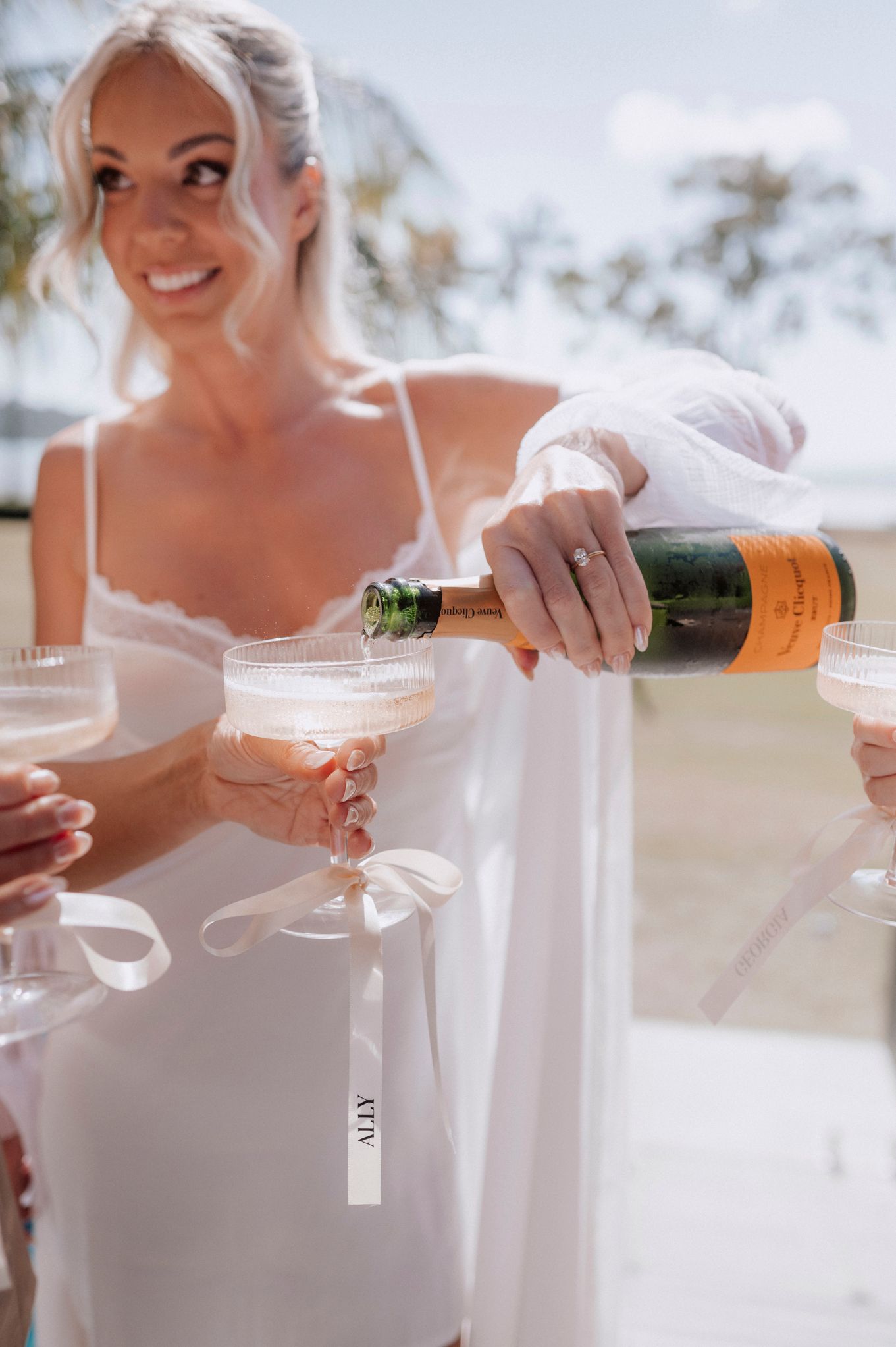 Pouring champagne into crystal glasses at an elegant outdoor celebration.