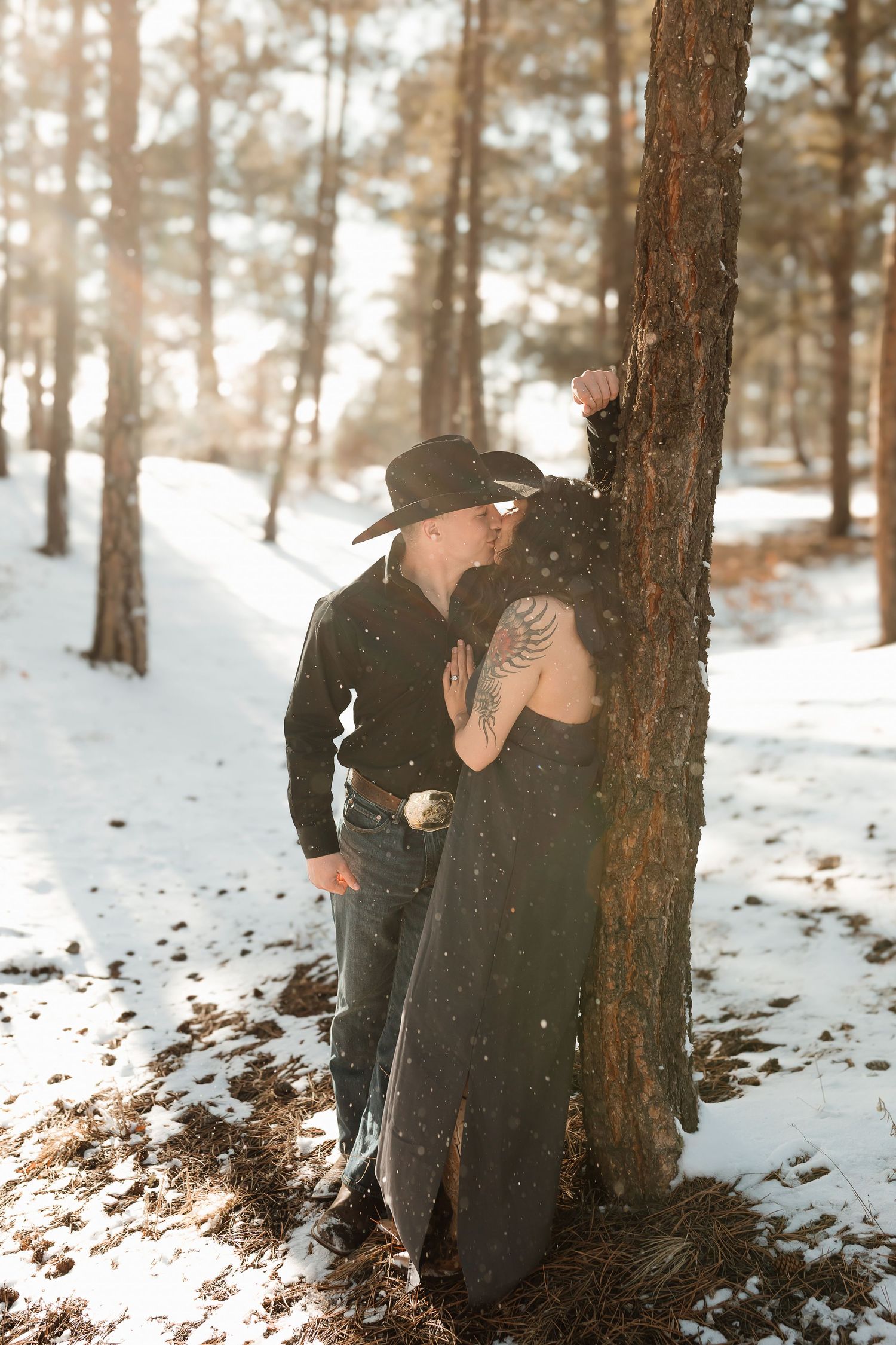 Three photos of a snowy winter scene in a forest with pine trees and a romantic moment captured against a tree trunk.