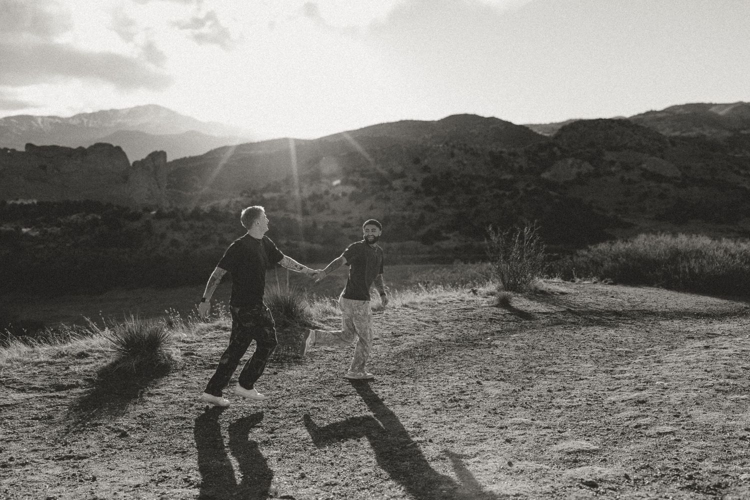 A series of black and white photos showing people exploring rocky mountainous terrain at sunset.