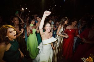 A lively reception dance party with people celebrating on the dance floor in formal evening wear.