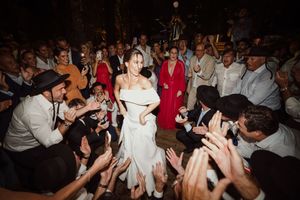 Dancers fill a crowded dance floor as party guests move energetically to the music at a wedding reception.
