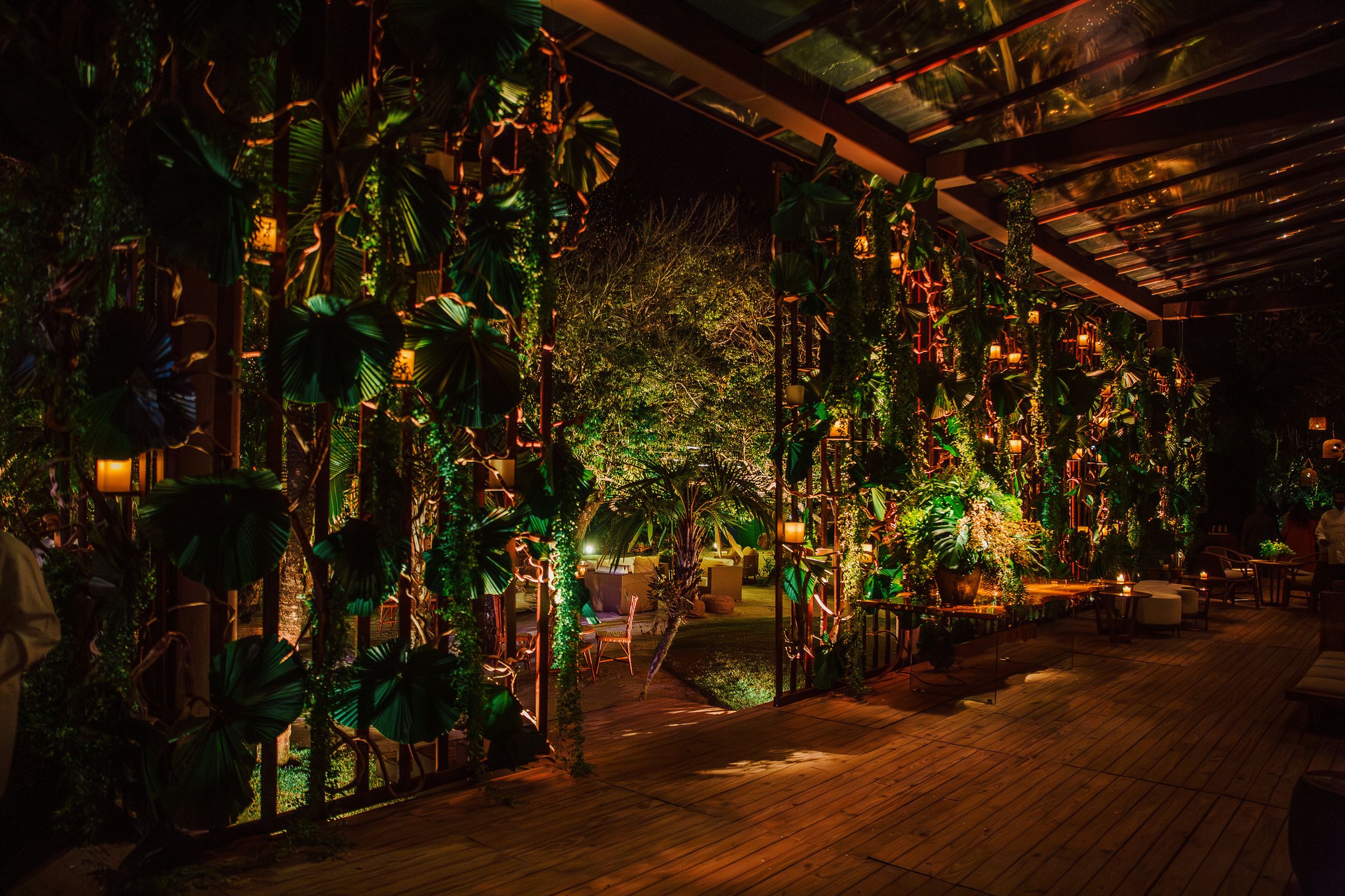 Enchanting outdoor patio decorated with hanging plants and warm string lights creating a magical nighttime atmosphere.