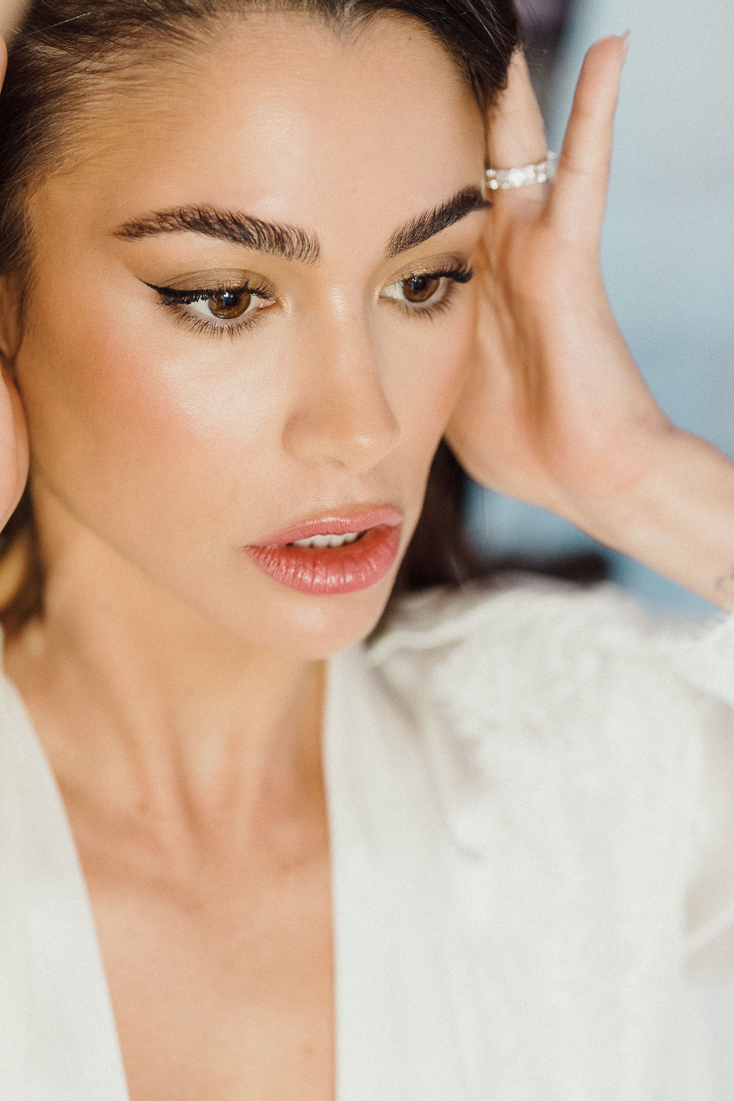 Close up beauty portrait showing natural glowing makeup and delicate pearl ring.