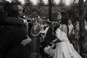 A couple shares a romantic first dance at their outdoor garden wedding celebration while guests watch.