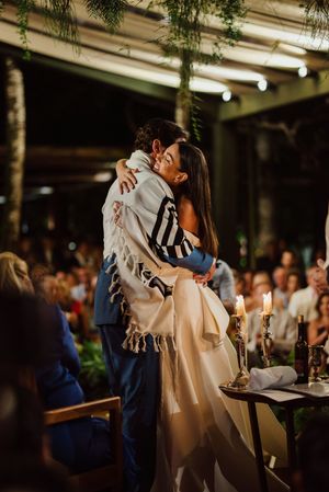 A couple shares an intimate dance at their wedding reception, surrounded by soft lighting and elegant decor.