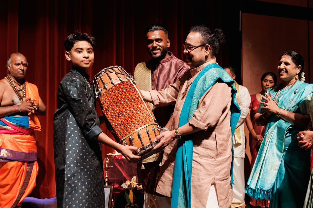 Performers in colorful Indian attire interacting during a stage production.