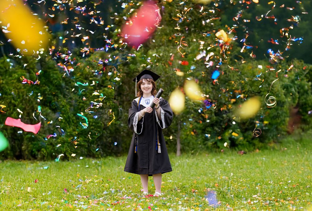 Graduate celebrates outdoors with colorful confetti floating through the air. Photos by Tampa Photographer DigitalMyst Photography