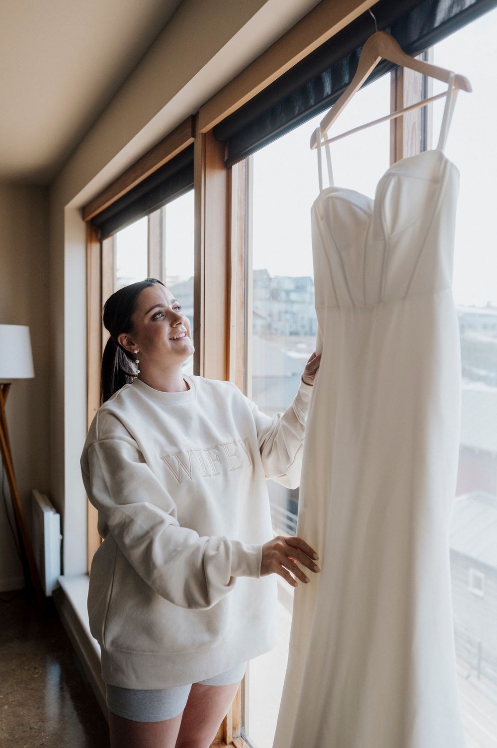 A series of photos showing someone in a white sweater joyfully interacting with window curtains in a bright interior space.