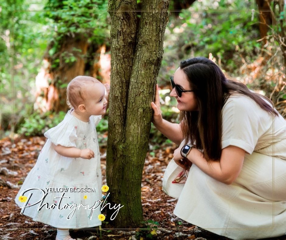 Sweet moment shared between baby and caregiver on a sunny afternoon in a wooded natural setting.