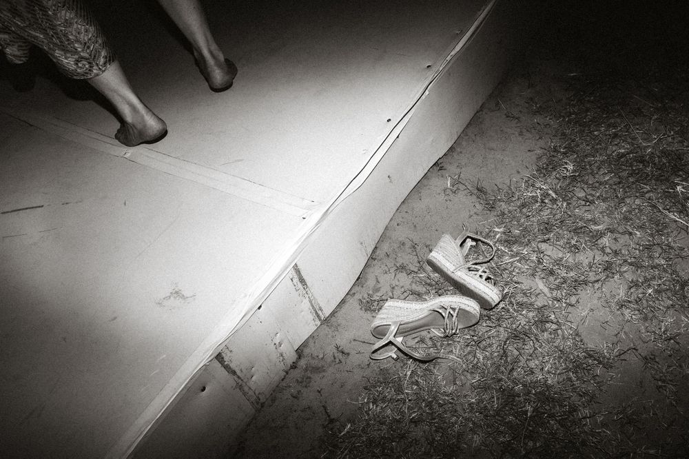An artistic black and white photo showing feet and scattered items on a dance floor.