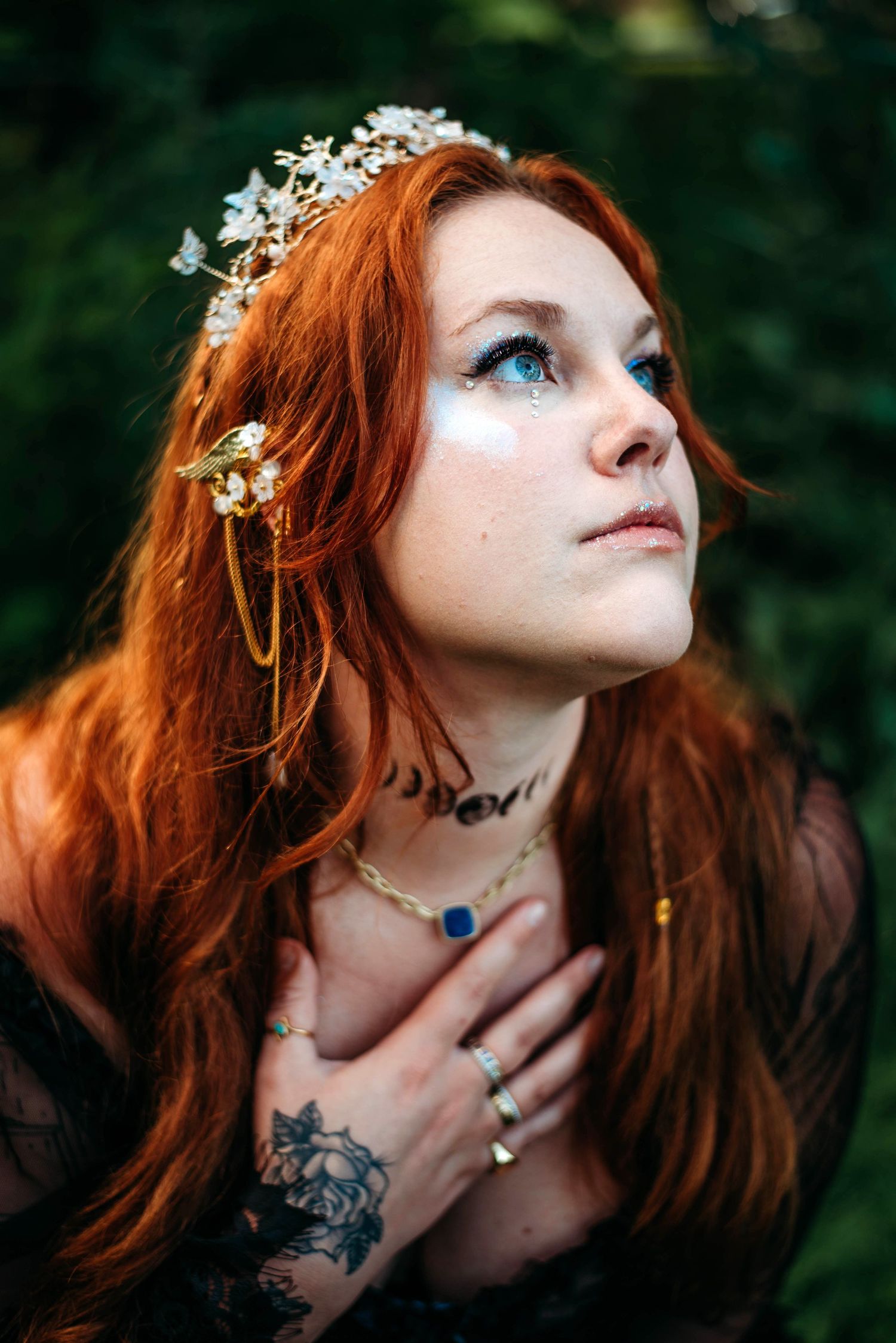 Portrait of a woman with red hair wearing a floral crown against a dark green background. Fantasy photoshoot in VA.