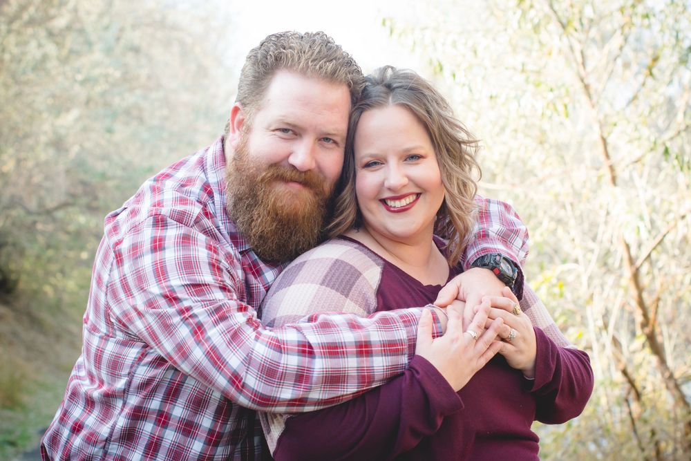 A couple shares tender moments together outdoors during a backyard photoshoot in autumn lighting.