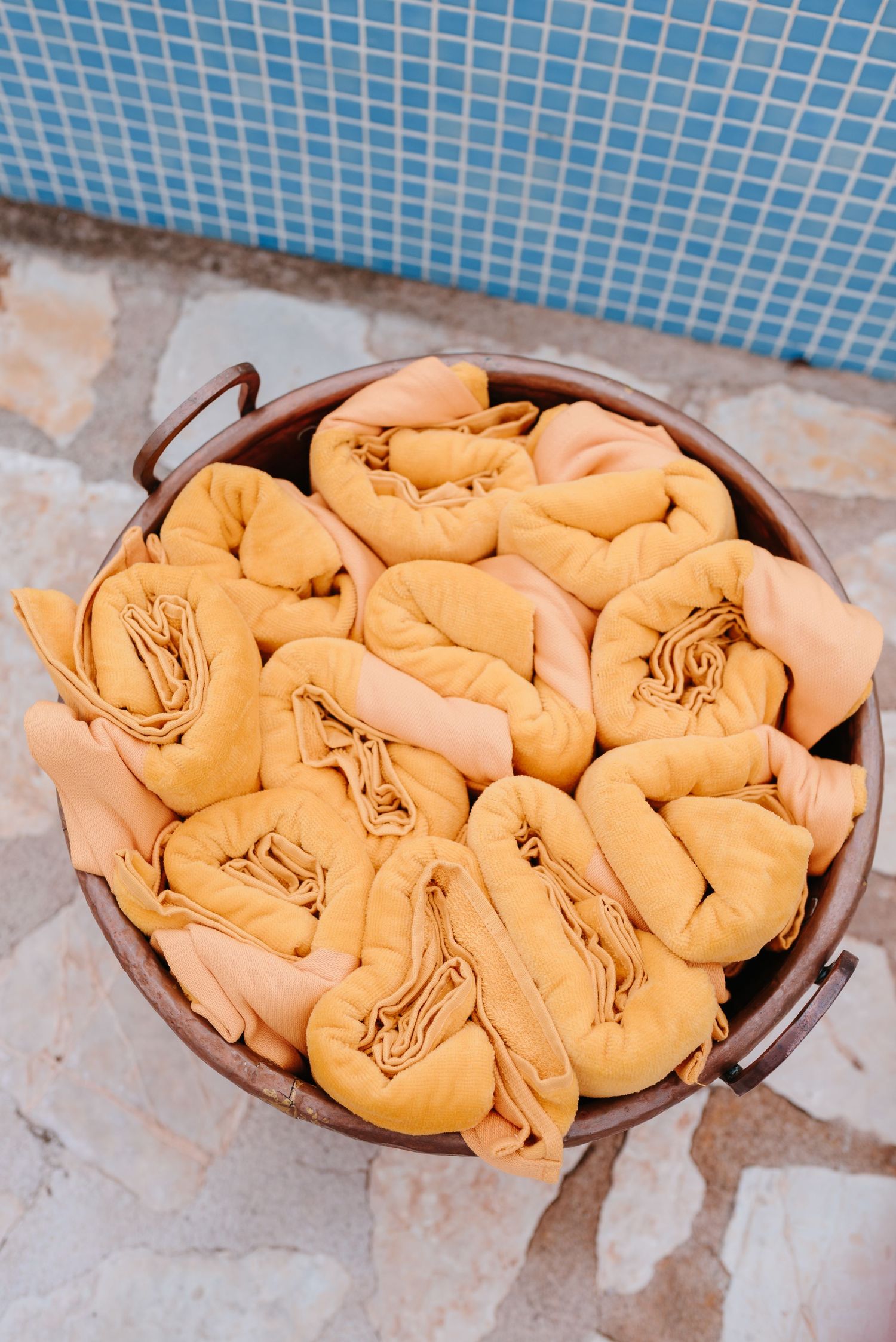 Homemade peach dumplings arranged in a circular pattern within a brown baking dish show stages of preparation.