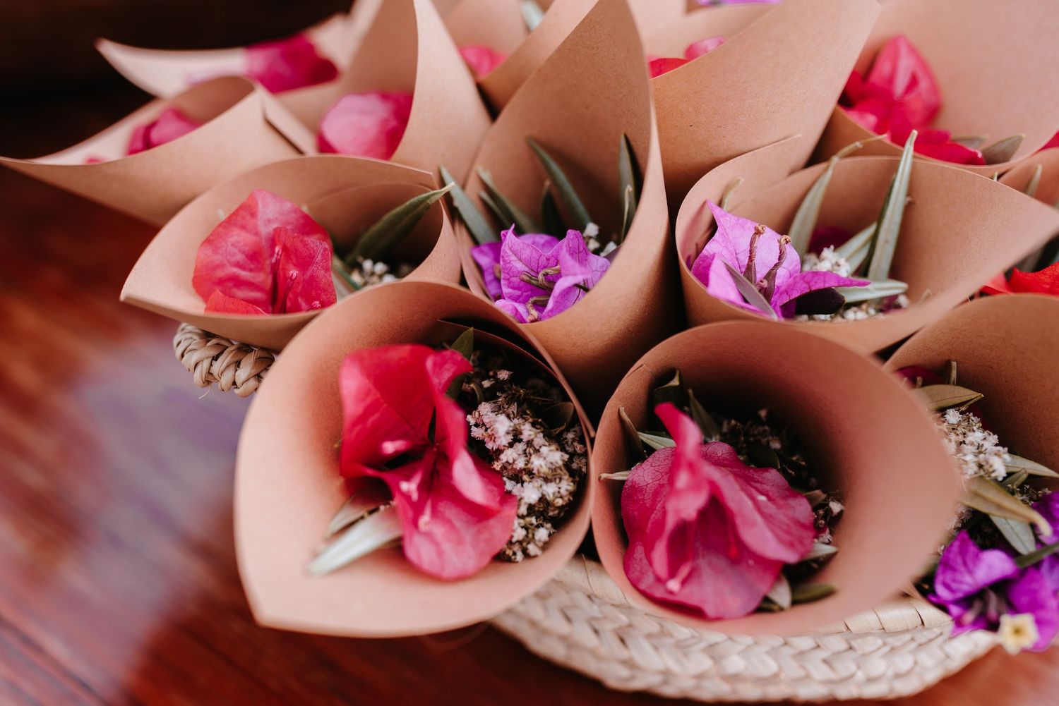Zarte rosa Blüten und weißes Schleierkraut, arrangiert in brauner Papierverpackung, ergeben eleganten Streublüten für den Auszug des Paares.