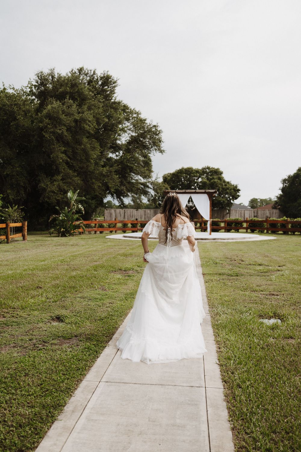 A sequence of photos showing a wedding dress flowing behind someone walking down a concrete path through a grassy field.