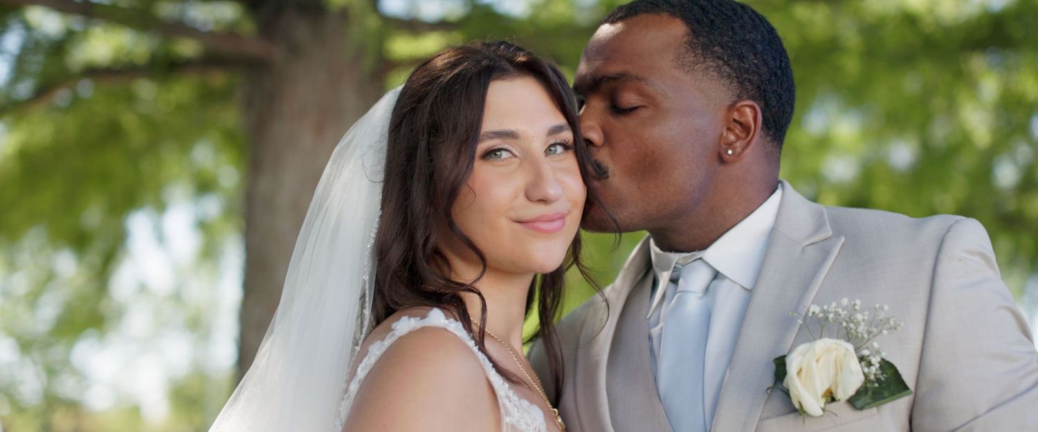A couple shares intimate moments in a garden setting during their wedding celebration.