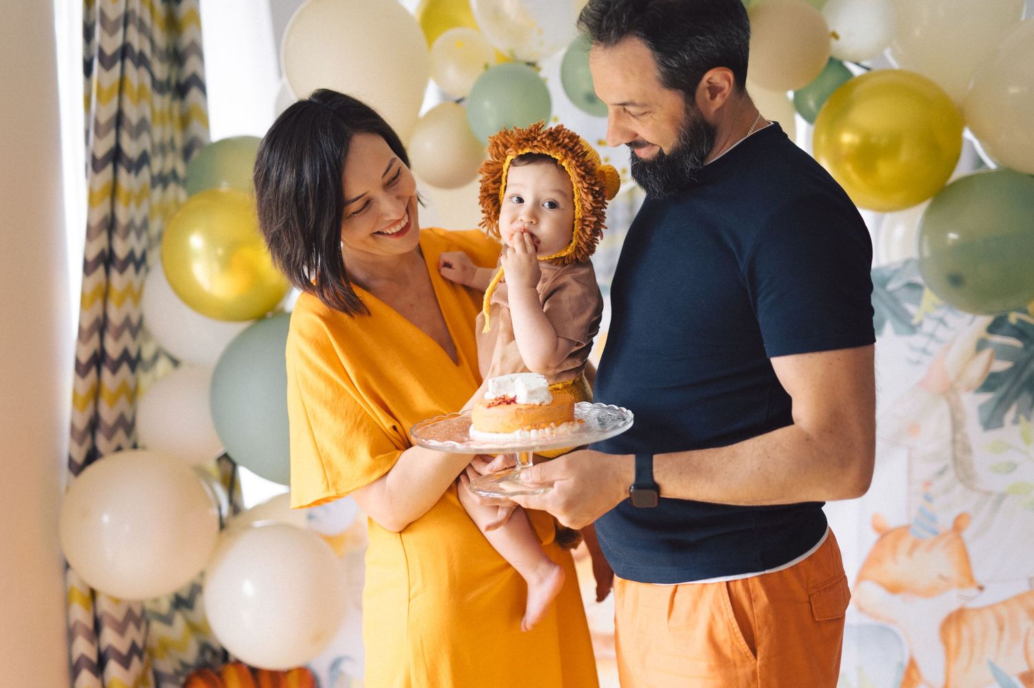 Family celebrating with gold and white balloons surrounded by decorations while embracing each other.