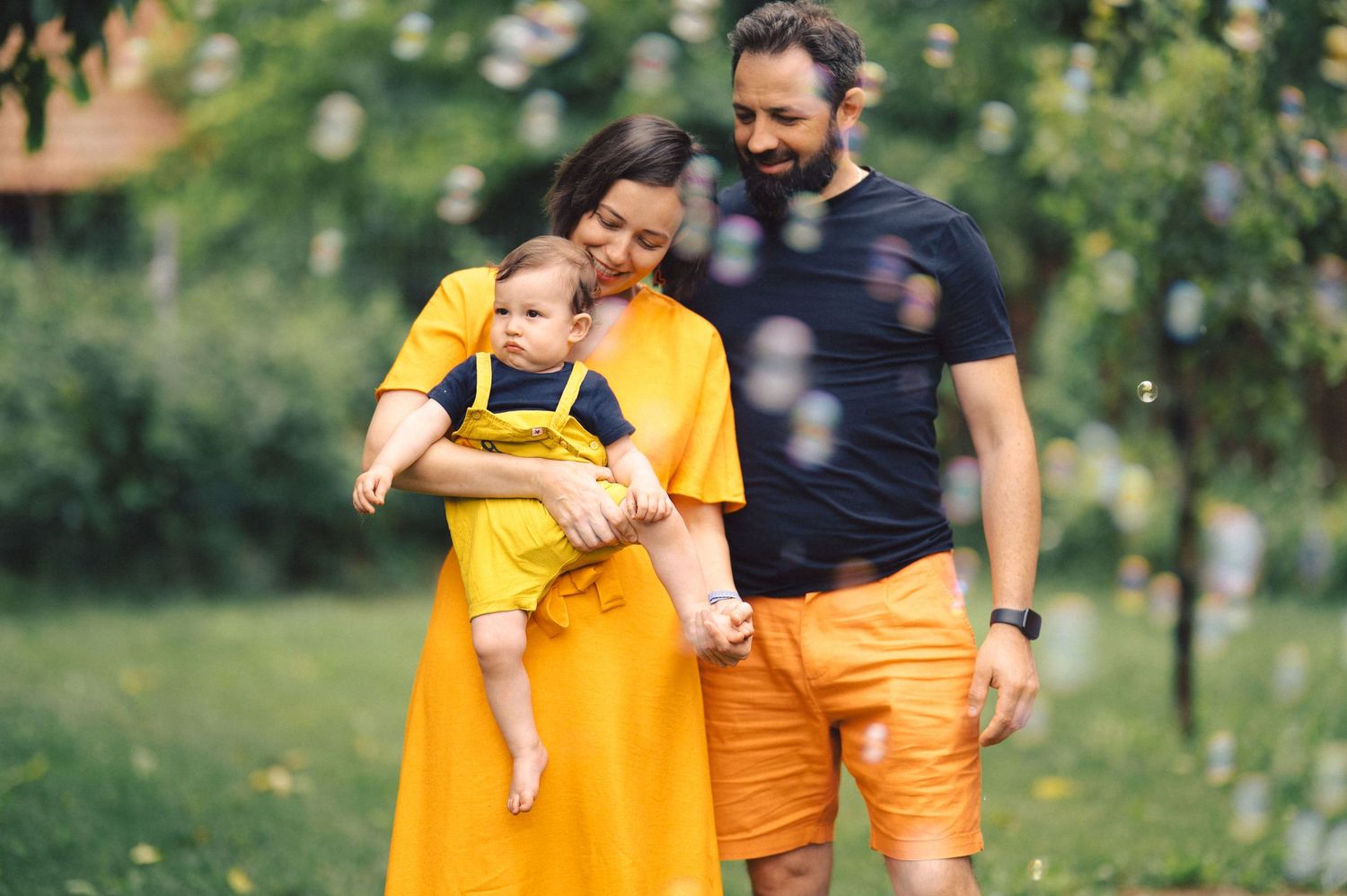 Collage of seven photos showing parents in yellow shirts outdoors with baby in a nature setting.