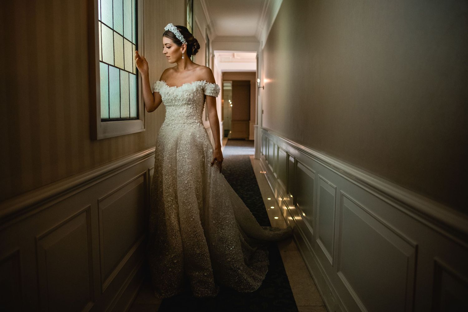Elegant wedding photography in a minimalist hallway with dramatic lighting.