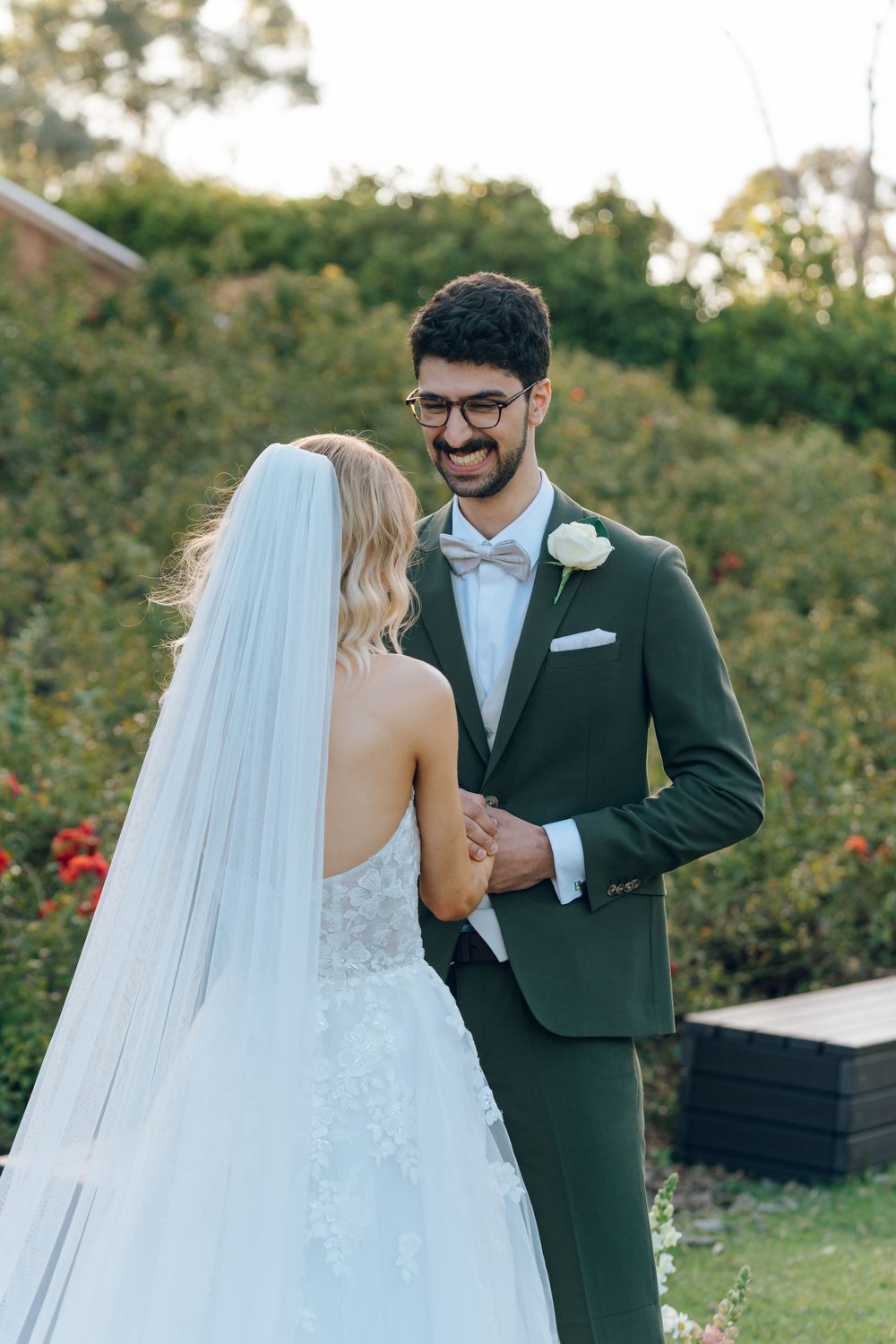 A romantic wedding moment in a garden with blooming flowers.