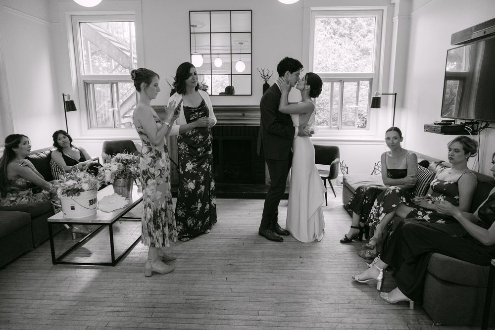 Group of people gathered in a cozy indoor living room space during an intimate gathering or celebration moment.