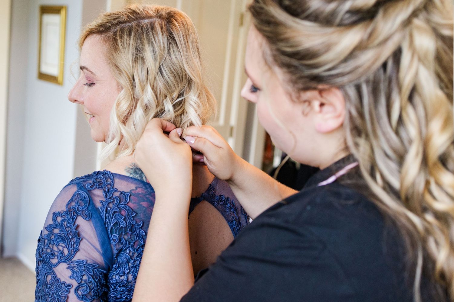 Styling hair with elegant blue lace dress detail visible.