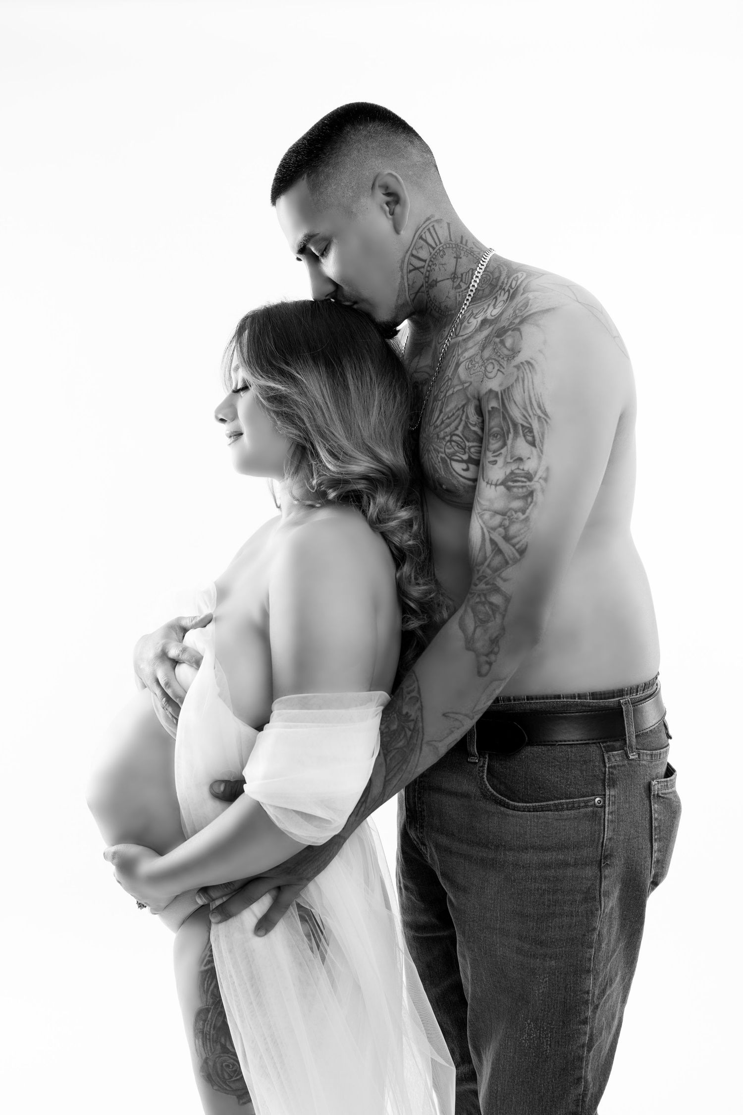 Artistic maternity photo featuring flowing white fabric against a brown backdrop creating an ethereal effect.