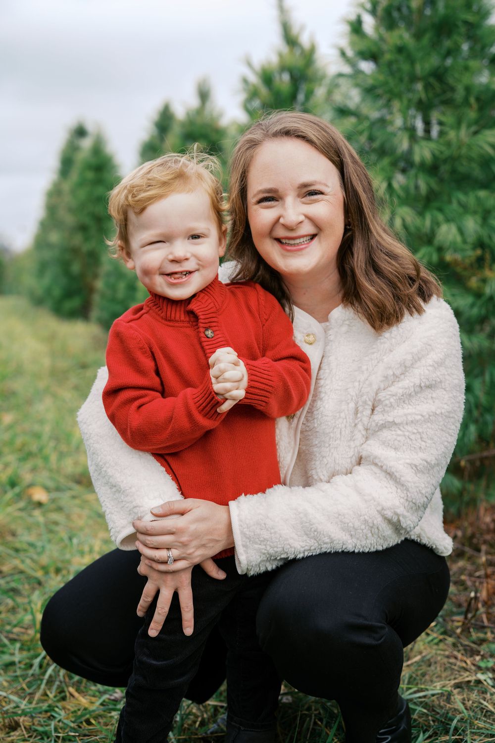Sweet portrait of two people sharing a happy moment among Christmas trees.
