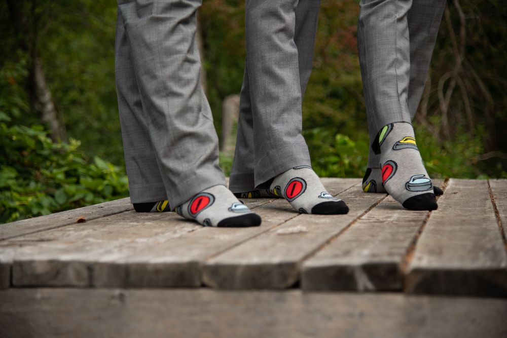 Close-up of three pairs of matching grey and red socks on wooden deck.