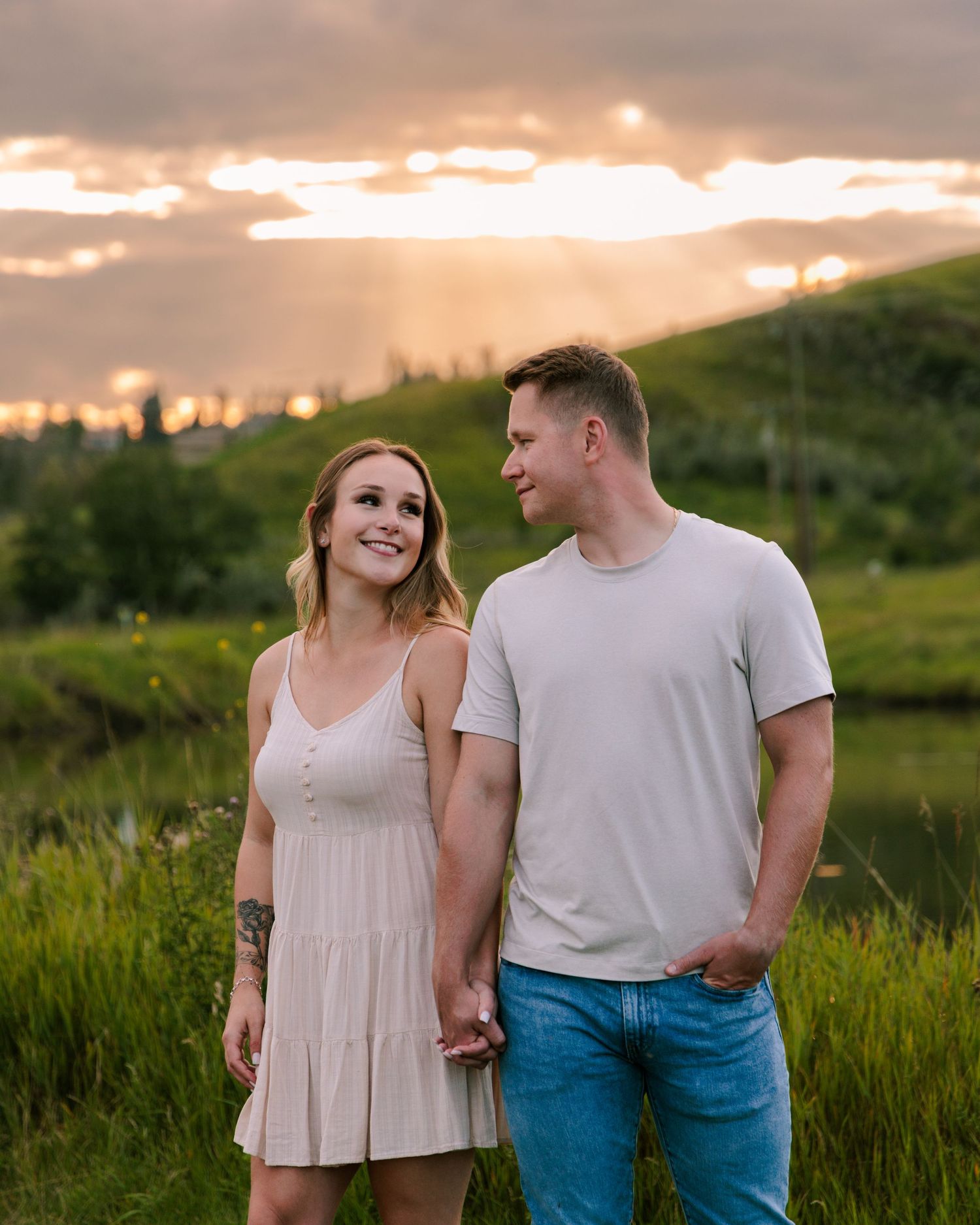 A couple shares intimate moment at sunset in mountain meadow.
