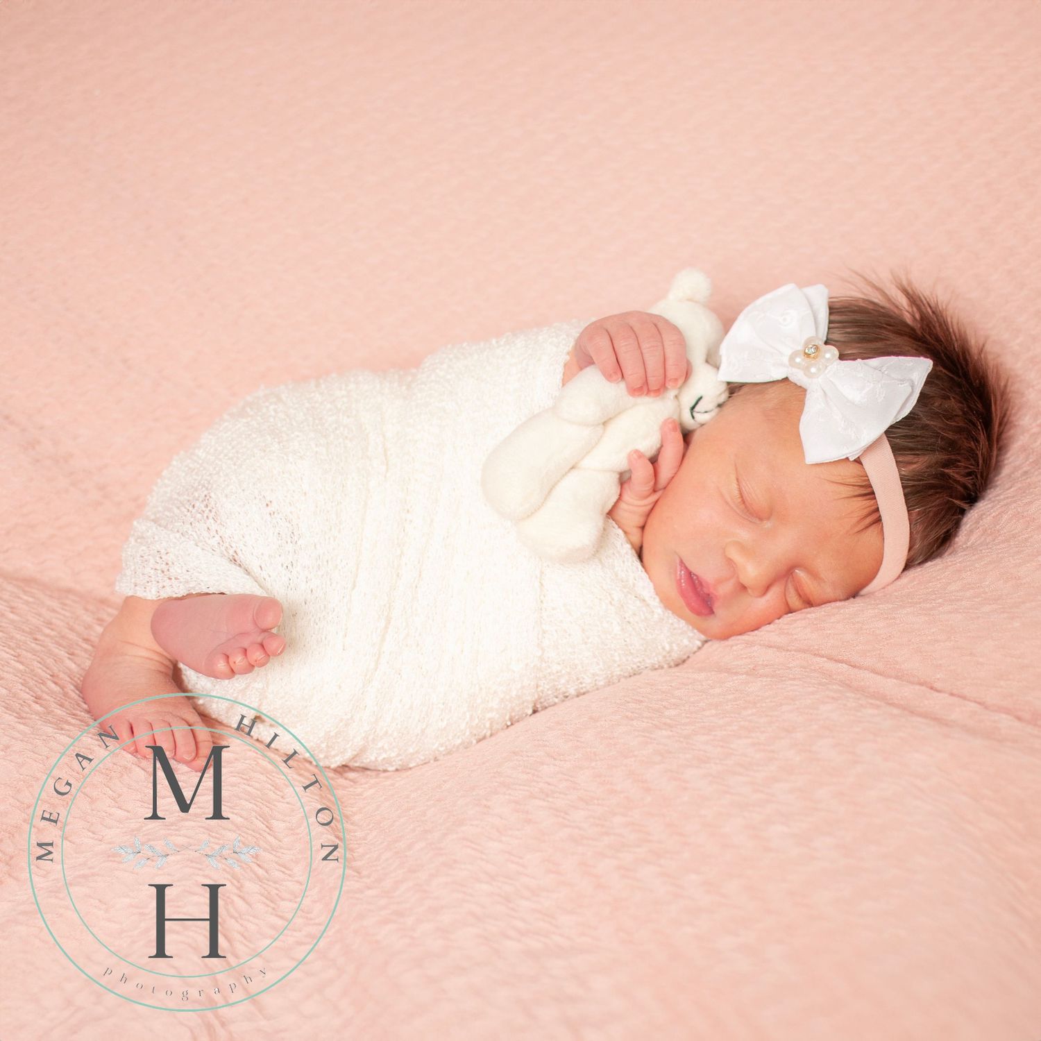 Full body photo of a newborn girl holding a teddy