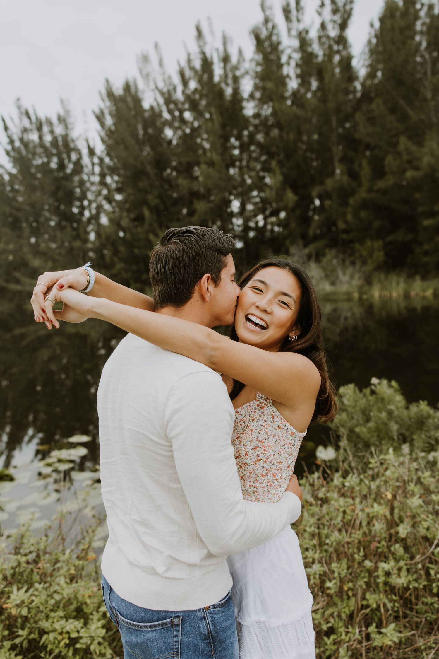 Woodsy couple photos at the West Delray Regional Park with a lake and tall trees during golden hour captured by Lindsay McDow Photography.
