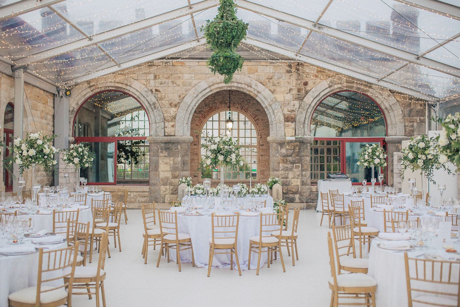 Elegant wedding reception at forte da cruz, and tall white floral centerpieces on round tables. captured by a Lisbon wedding photographer