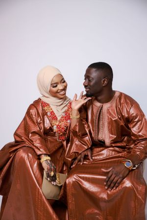A couple in matching brown traditional garments and hijab share intimate moments across a series of progressive poses.