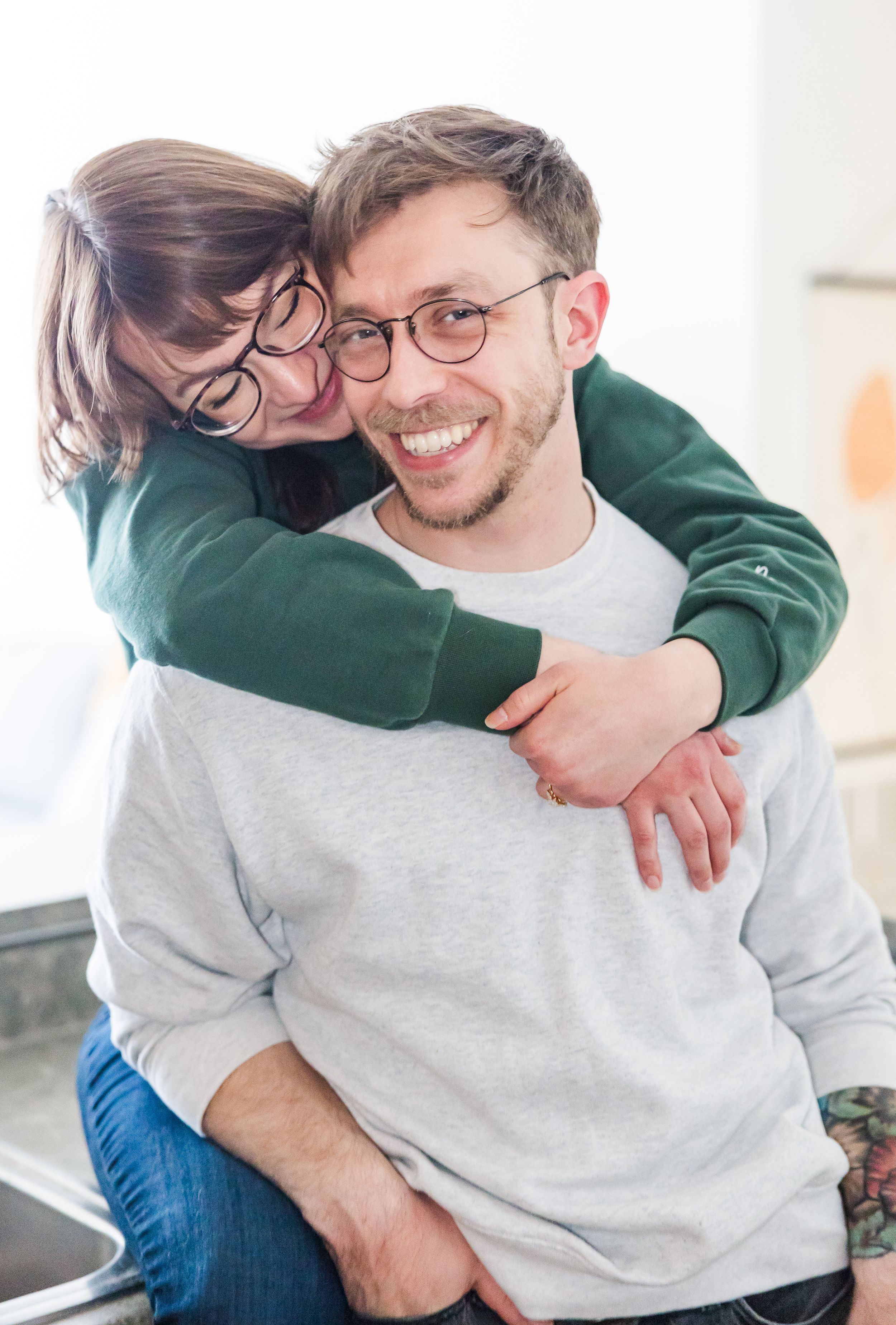 A joyful moment shared between two people wearing casual sweaters.