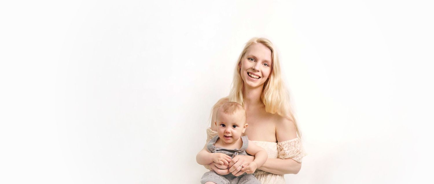 Family pregnancy photoshoot in Ross on wye. Mother is holding her baby and smiling at the camera