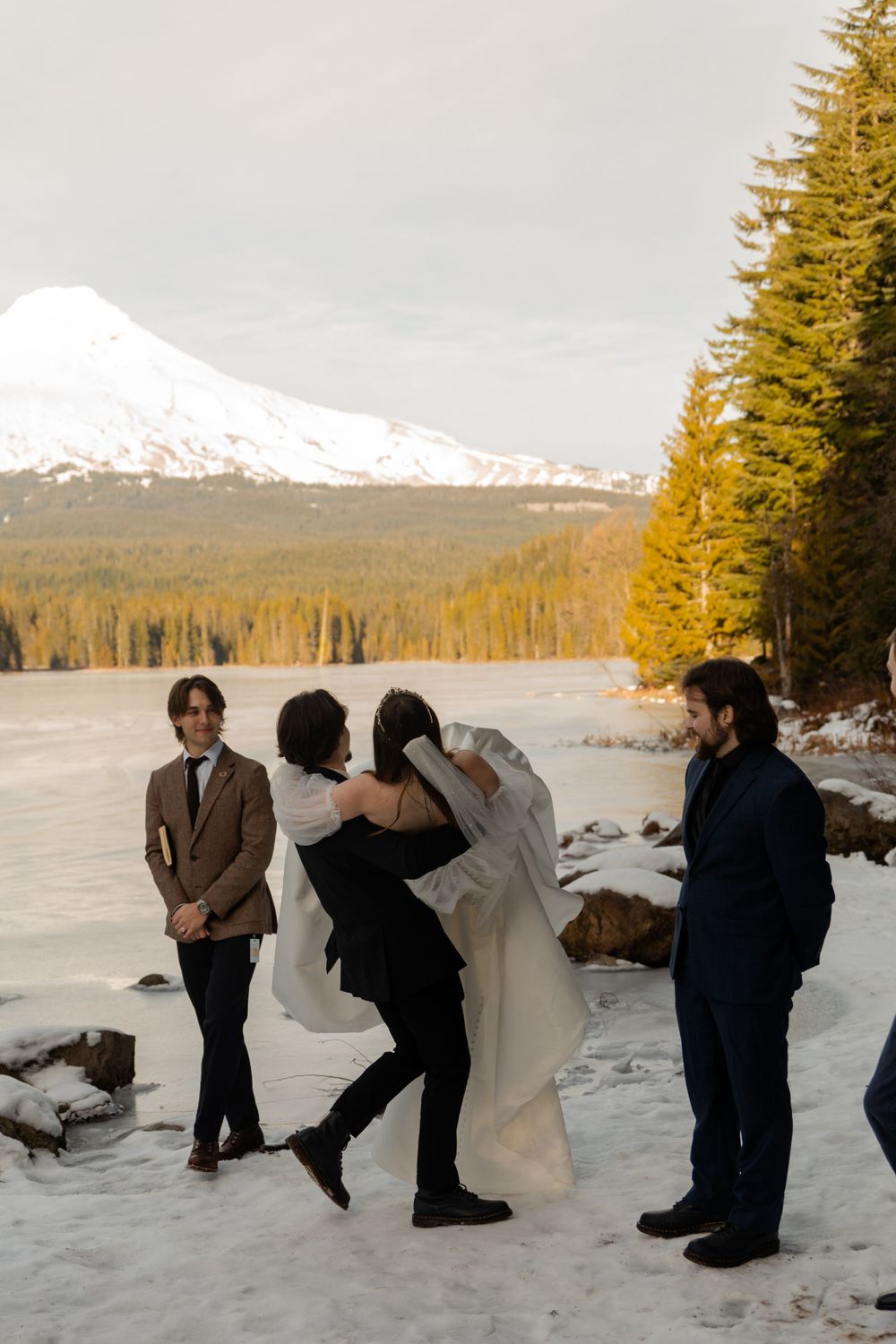 Mountain wedding celebration with snow-capped peak visible in distance.