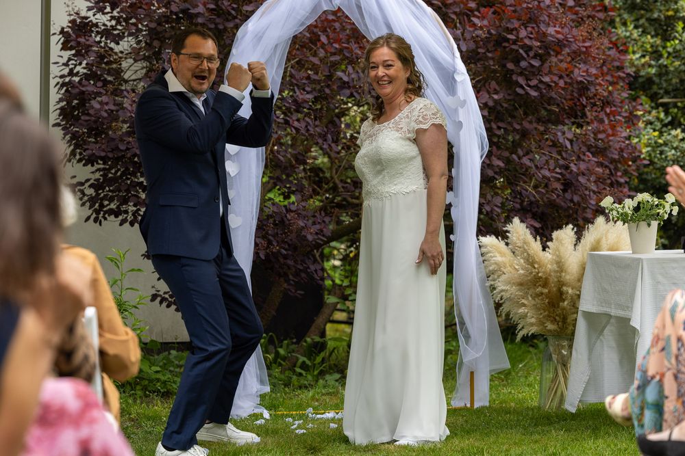 Bruidegom juicht nadat ze officieel getrouwd zijn  - documentaire bruidsreportage aan huis - Teteringen eigen achtertuin - MaxFotos